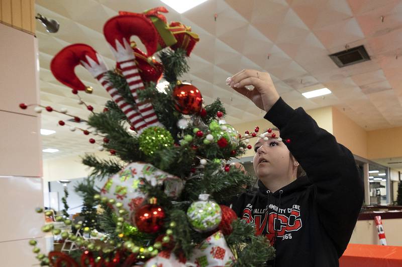 Brooke Danreiter fixes up a small school tree Sunday, Nov. 17, 2024, for the Festival of Trees. This tree was sponsored by East Coloma-Nelson paraprofessionals. Along with the 25 large trees, Rock River Hospice also has on display several smaller trees donated from local schools.