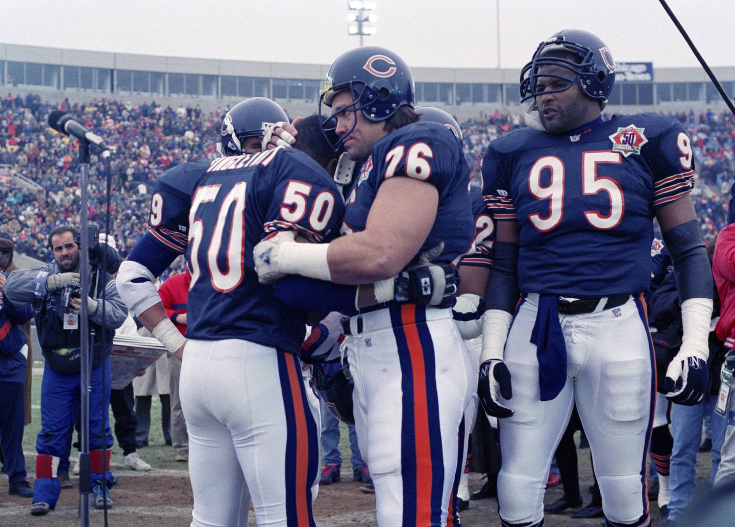 FILE - Chicago Bears nine-time Pro Bowler Mike Singletary (50) gets a bear hug from teammate Steve McMichael (76) prior to an NFL football game against the Pittsburgh Steelers in Chicago, Dec. 13, 1992. McMichael will be inducted into the Pro Football Hall of Fame Saturday, Aug. 3, 2024. (AP Photo/David Boe, File)