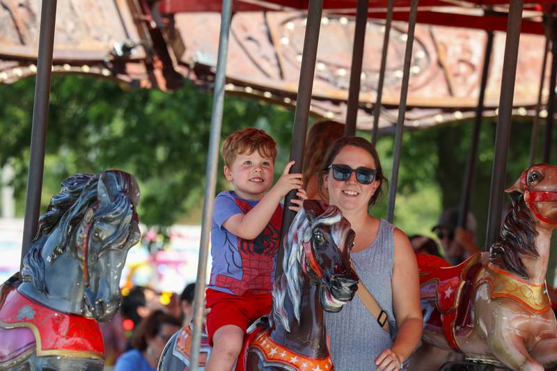 Wyatt Daily, 3, enjoys the merry-go-round with his mom, Amy Daily, both of Bourbonnais, at the Kankakee County Fair on Saturday, Aug. 2, 2025.