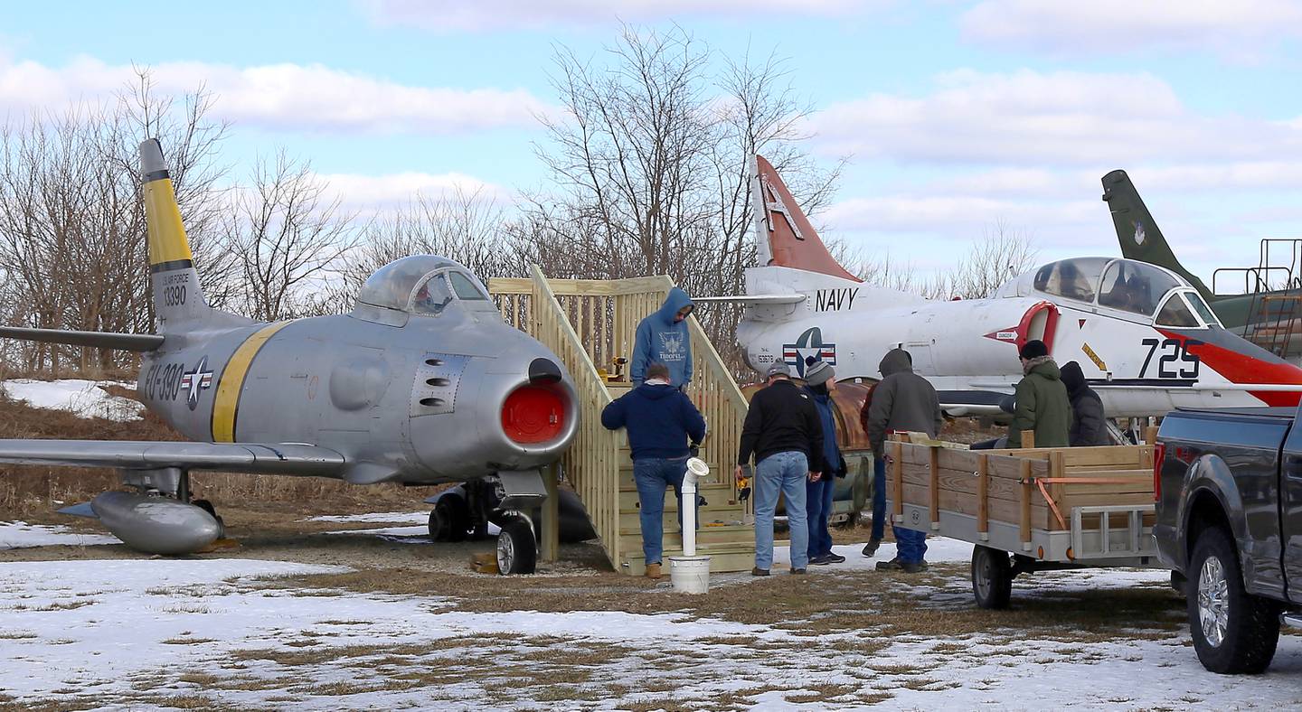 Boy Scouts, scout leaders and scout dads assist Logan Cunz with his Eagle Scout project at the Air Classics Museum in Sugar Grove on Sunday, Feb. 13, 2022.