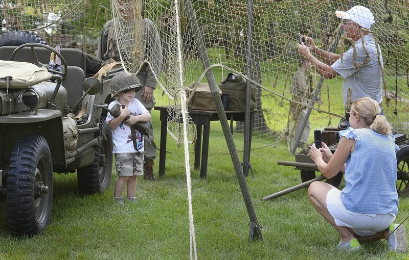 A child gets his picture taken in front of a military vehicle Saturday, July 15, 2023, during the Ottawa Military Show, north of Ottawa.