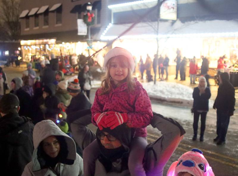 Olivia Squires, 6, of Huntley sits atop her dad Bob’s shoulders as they await the lighting of the town during A Very Merry Huntley on Saturday, Dec. 6, 2025.