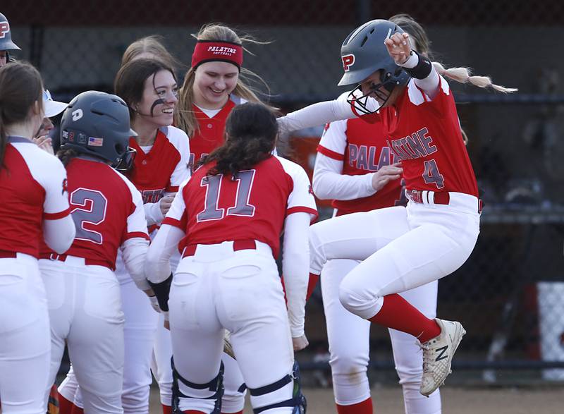 Palatine’s Lauren Dettloff jumps into her teammates after hitting a home run during a non-conference softball game against Jacobs Monday, March 20, 2023, at Palatine High School.