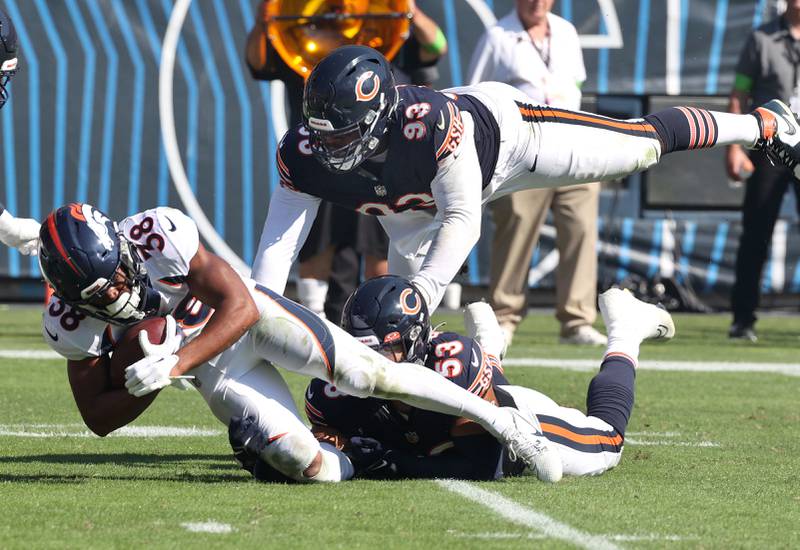 Chicago Bears defensive tackle Justin Jones and Chicago Bears linebacker T.J. Edwards bring down Denver Broncos running back Jaleel McLaughlin during their game Sunday, Oct. 1, 2023, at Soldier Field in Chicago.