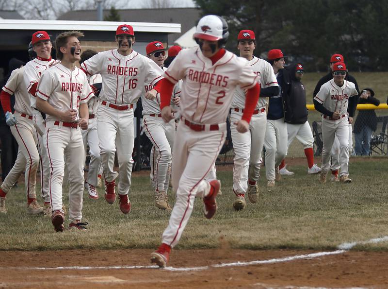 Huntley players run onto the filed as Huntley's Kyle Ziebell runs to home after Joey Lengle walked in the ninth inning scored a run to win a nonconference baseball game against Fremd on Tuesday, March 24 2026, at Huntley High School.