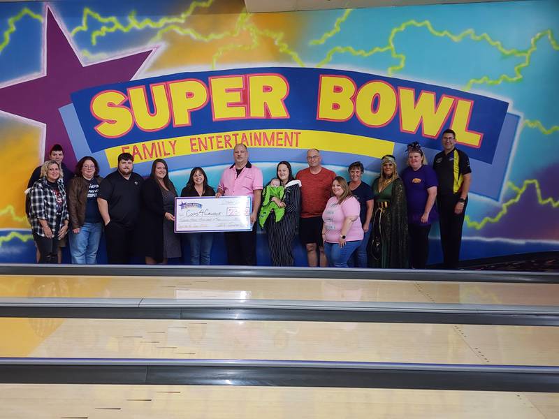 The Illinois Valley Super Bowl in Peru presented a check for $23,000 to Cops4Cancer from its Bowl for the Cure event. Volunteers were (left to right) Michelle Brown, Andy Brown, Denise Harper, Eddie Wojcik, Nicole Sheppard, Cops4Cancer President Betty Glynn, Bowl for the Cure Organizer Dan Sheppard, volunteers Trista Marquez, Jim Cuchiara, Danielle DeCarlo, Ivy Cuchiara, Kim Borio, Jodi Hampton and IV Super Bowl owner Eric Acuncius.