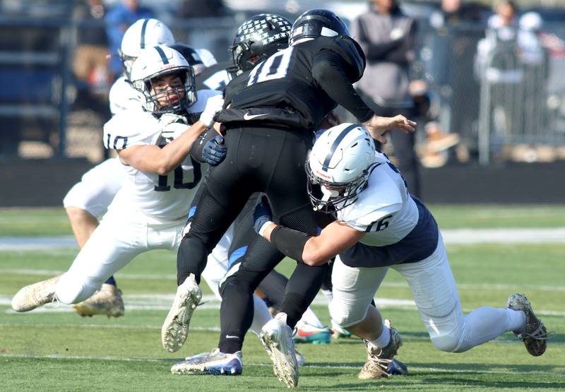 Cary-Grove’s Thomas Battaglia, left, and Connor Mattran, right, bring down Highland Park’s David Finfer in second-round IHSA Class 6A playoff action at Wolters Field in Highland Park Saturday.