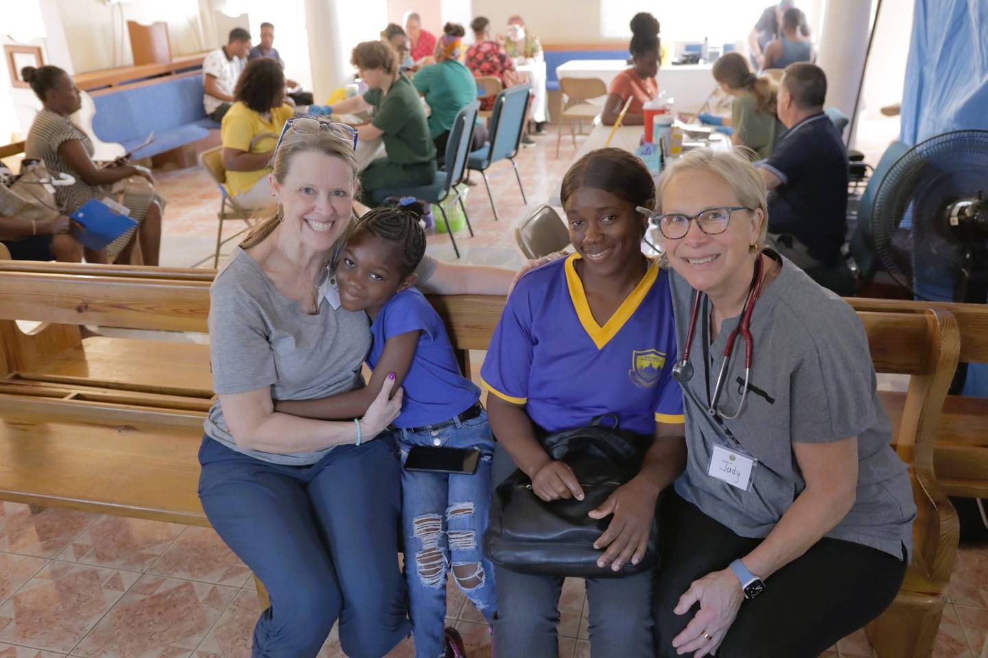 Northwestern Medicine registered nurses Kate Brania, far left, and Judy Wett, far right, help two patients during their trip to Negril, Jamaica with The Joshua Mission.