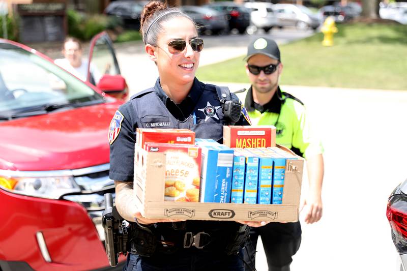 Community Engagement Officer Crystal Miroballi and Community Service Officer Josh Babor load donations as part of the Wheaton Police Department’s Stuff the Squad event on Wednesday, July 20, 2022. All donations will be distributed by the People’s Resource Center to anyone in need.