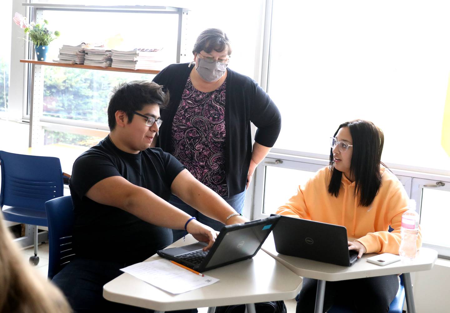 Substitute teacher Jennifer Murphy works with Kaneland High School seniors Kirk Blanco and Abigail Burroughs. Murphy just began an assignment as a long-term substitute teacher at the school.