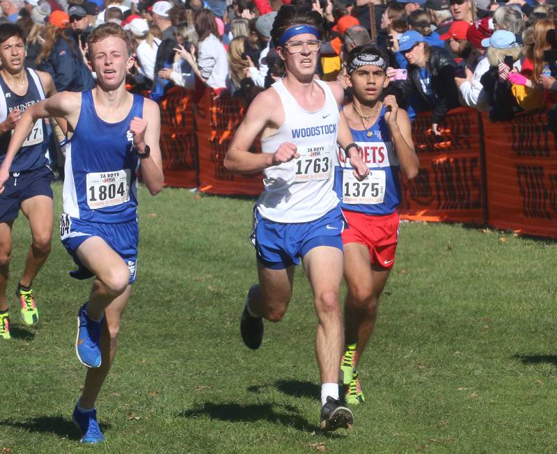 Wheaton St. Francis Charlie Coyle, Woodstock's Cohen Shutt and Marmion Academy's Jesse Carlos compete in the Class 2A State Cross Country race on Saturday, Nov. 4, 2023 at Detweiller Park in Peoria.