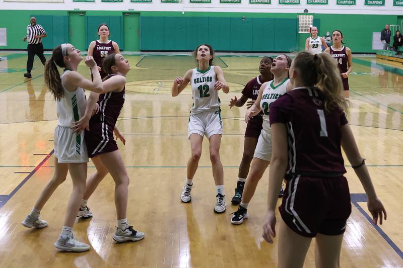 Players watch as Providence’s Gabi Bednar’s, 20, shot falls in for a basket against Lockport.