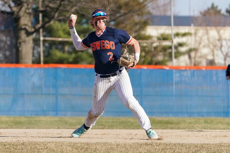 Oswego’s Easton Ruby (2) fields a grounder and throws to first for an out during a baseball game against Benet at Oswego High School on Tuesday, March 25, 2025.