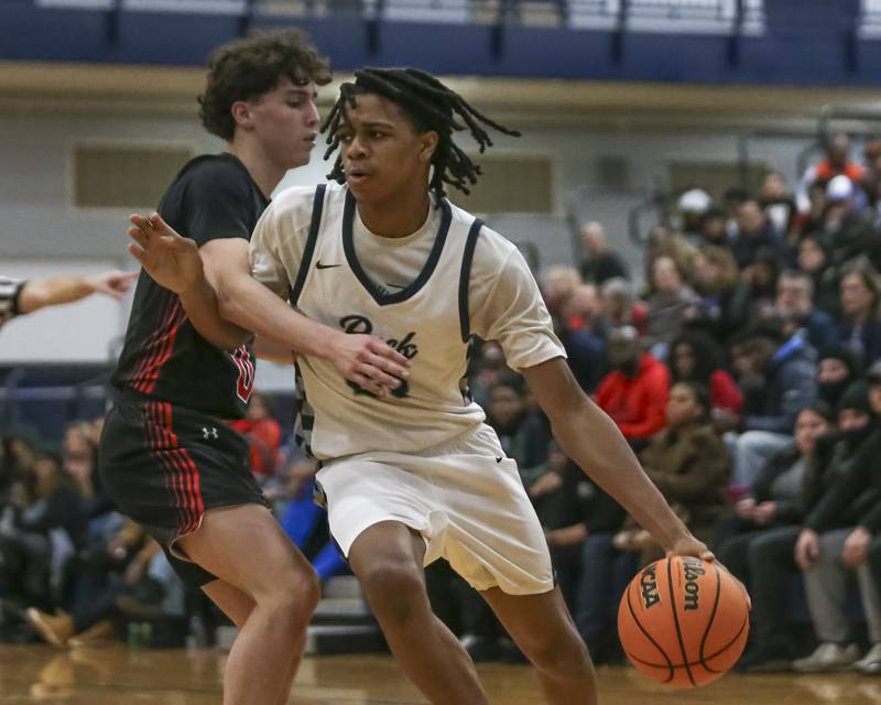 Oswego East's Mason Lockett (23) drives baseline during their basketball game between Yorkville at Oswego East. Friday, Dec 19, 2025 in Oswego.