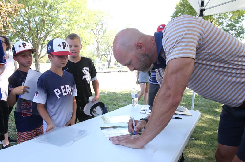 Former Major League pitcher J.A. Happ signs autographs for Geno Vezzetti his brother Luca and Logan Martin during the J.A. Happ Day and field dedication on Sunday, July 30, 2023 at Washington Park in Peru.