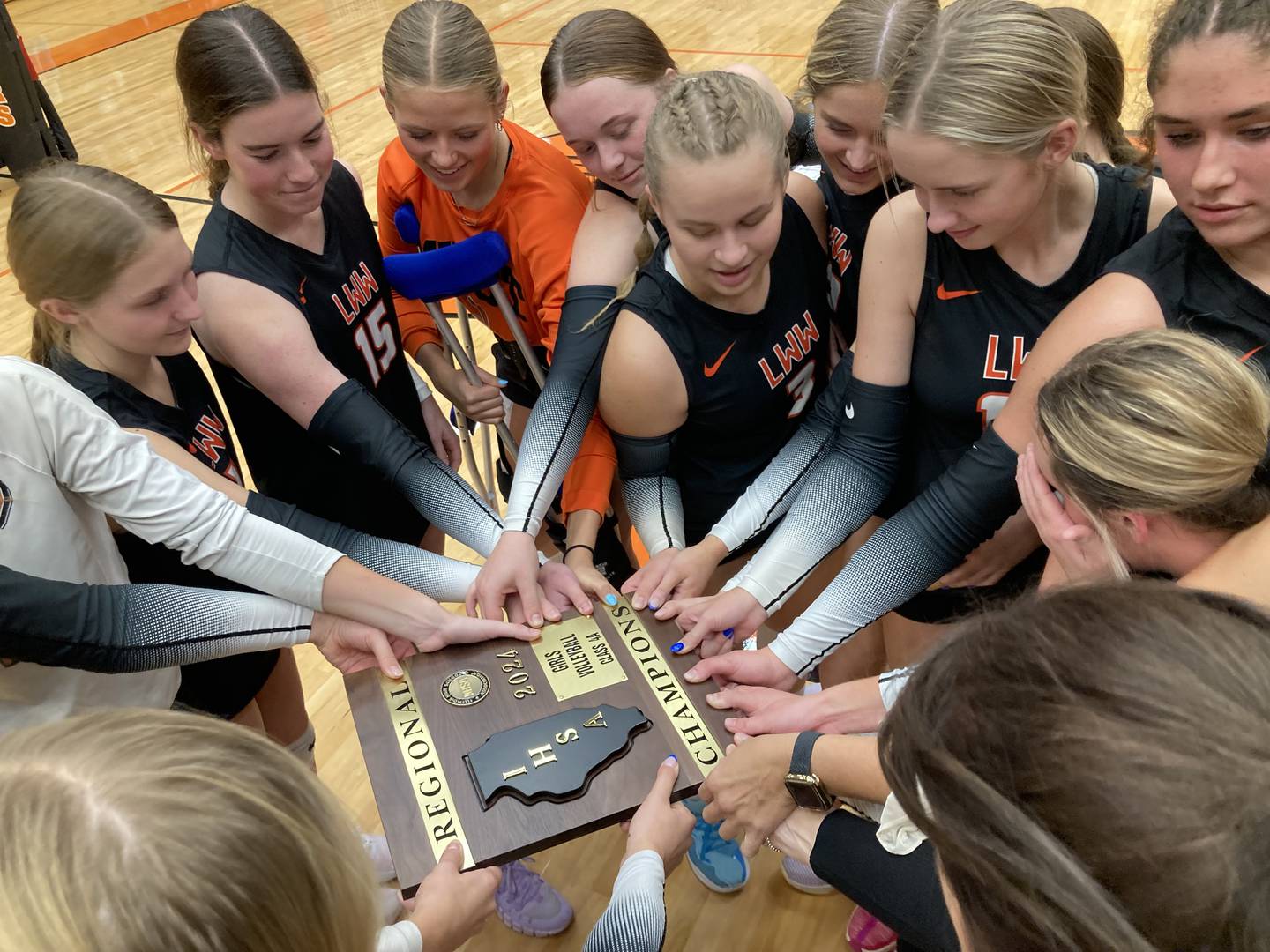The Lincoln-Way West volleyball team celebrates winning the regional championship.