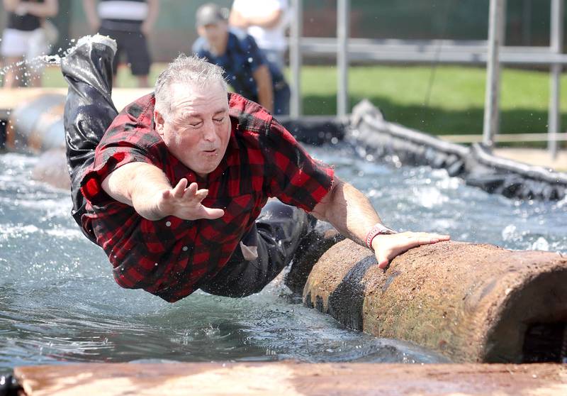 Travis Wells from Lumberjack Enterprises out of Minnesota dives for the finish line in the log running portion of the Lumberjack contest Wednesday, Sept. 7, 2022, on opening day of the Sandwich Fair. The fair continues this week through Sunday.