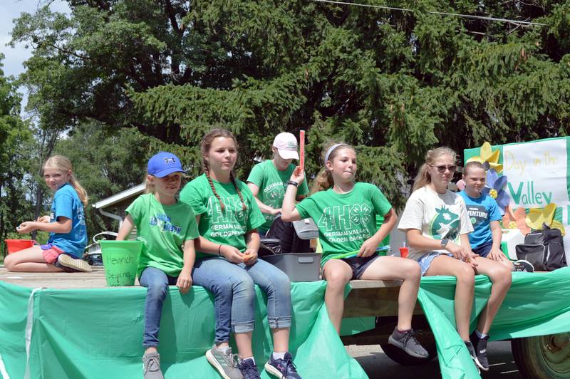 Members of German Valley Golden Eagles 4-H group ride their float in the German Valley Days parade on July 16, while throwing treats to parade attendees.