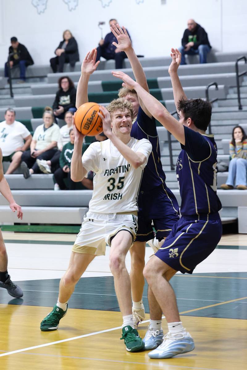 Bishop McNamara's Richard Darr drives to the basket under pressure during the Fightin' Irish's 62-25 victory over Chesterton Academy on Wednesday, Jan. 7, 2026.