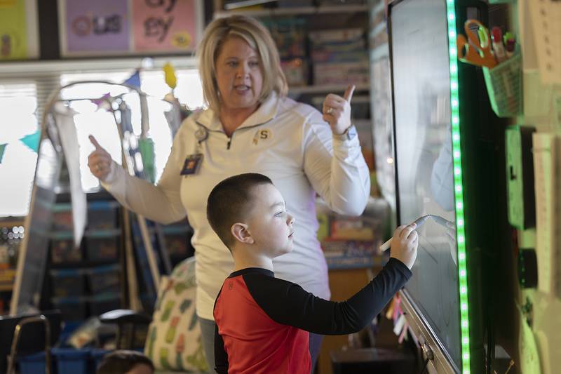 A young student works on a math problem on the smart board Friday, Feb. 7, 2025, with teacher Kristin Ports at Jefferson School in Sterling.