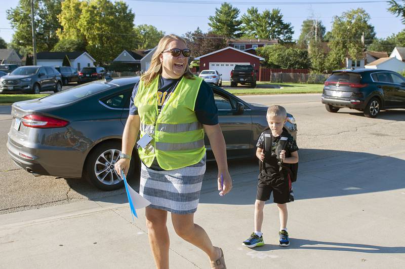 Jefferson School Principal Heather Wittenauer leads a student to his class during the first day of school in Sterling. During this first day, parents were allowed to follow their youngsters to the classroom if they desired.