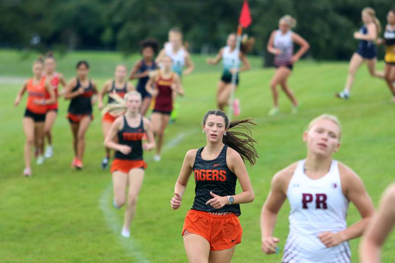 Girls compete in the varsity race during the McHenry County Cross Country Meet at Emricson park in Woodstock on Saturday, August 30, 2025.