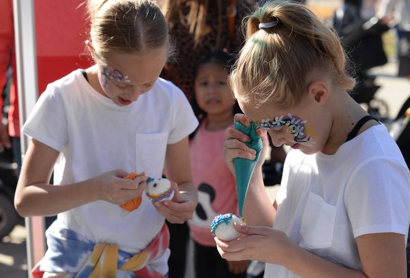 Children and families including (left) Camryn and Callie Kotyluk of Alsip make sugar skulls during the Day of the Dead event held at Brookfield Zoo Friday Oct 29, 2022.