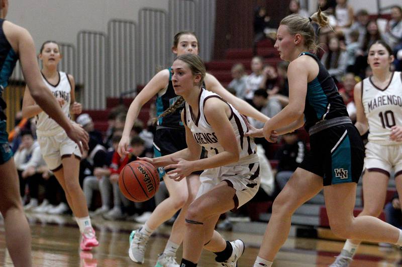 Marengo’s Emily Kirchhoff moves the ball against Woodstock North in varsity girls basketball at Marengo Tuesday evening.