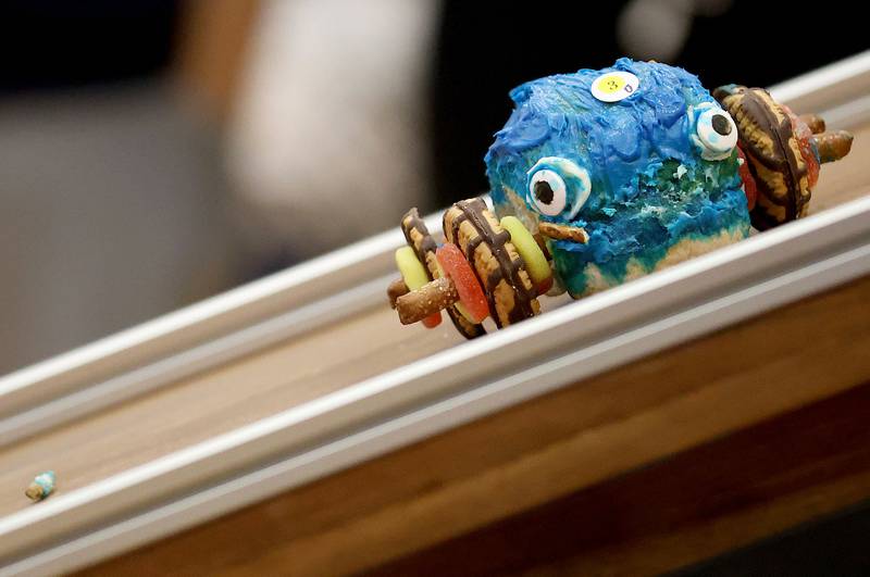 A giant blue whale food car loses a piece of it's pretzel rod as it turns sideways going down the ramp during the Edible Car Contest on Wednesday, Feb. 25, 2026 at Illinois Valley Community College in Oglesby.