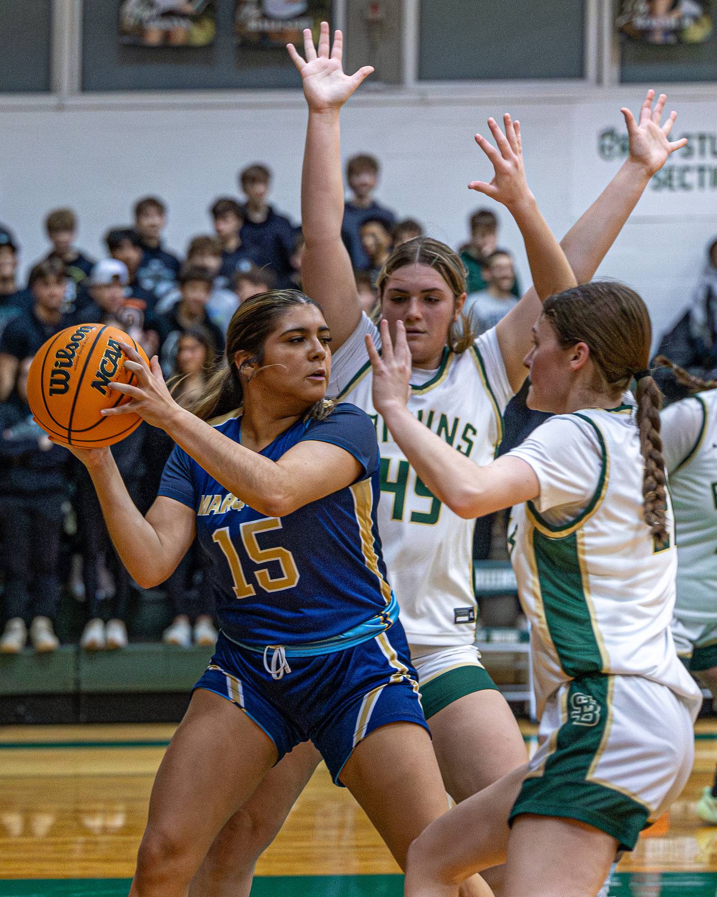 Senya Mitre (15) of Marquette holds ball whilst being surrounded by Savannah Bray (45) and Parker McClain (21) of St. Bede on Friday, January 16, 2026 at St. Bede Academy in Peru.