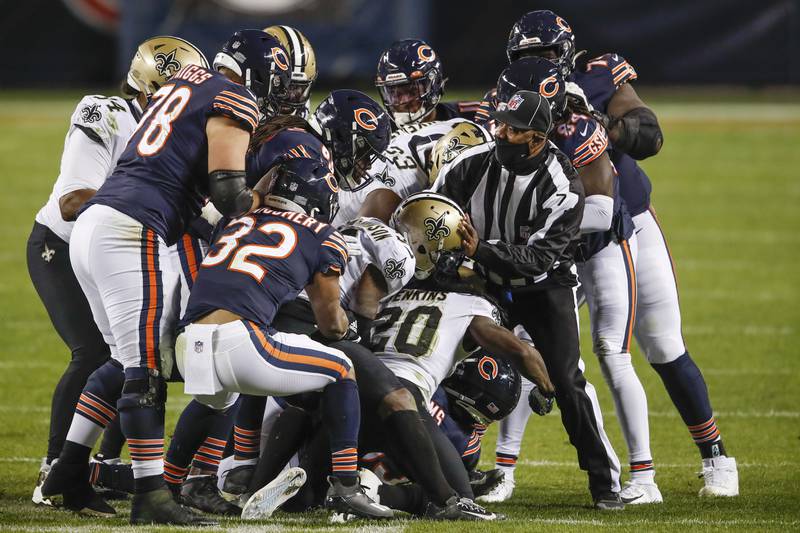 Side Judge Keith Washington (7) tries to separate the Chicago Bears and New Orleans Saints players during the second half of an NFL football game, Sunday, Nov. 1, 2020, in Chicago. (AP Photo/Kamil Krzaczynski)