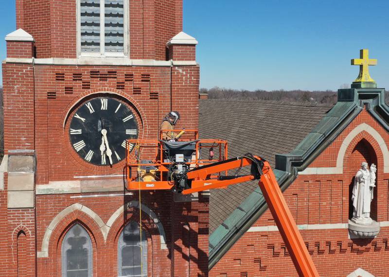 Workers tuckpoint spires on St. Hyacinth's Catholic Church on Tuesday, March 14, 2023 in La Salle. Last May, the church launched a $1.8 million capital campaign for a new roof, facade improvements and interior work.