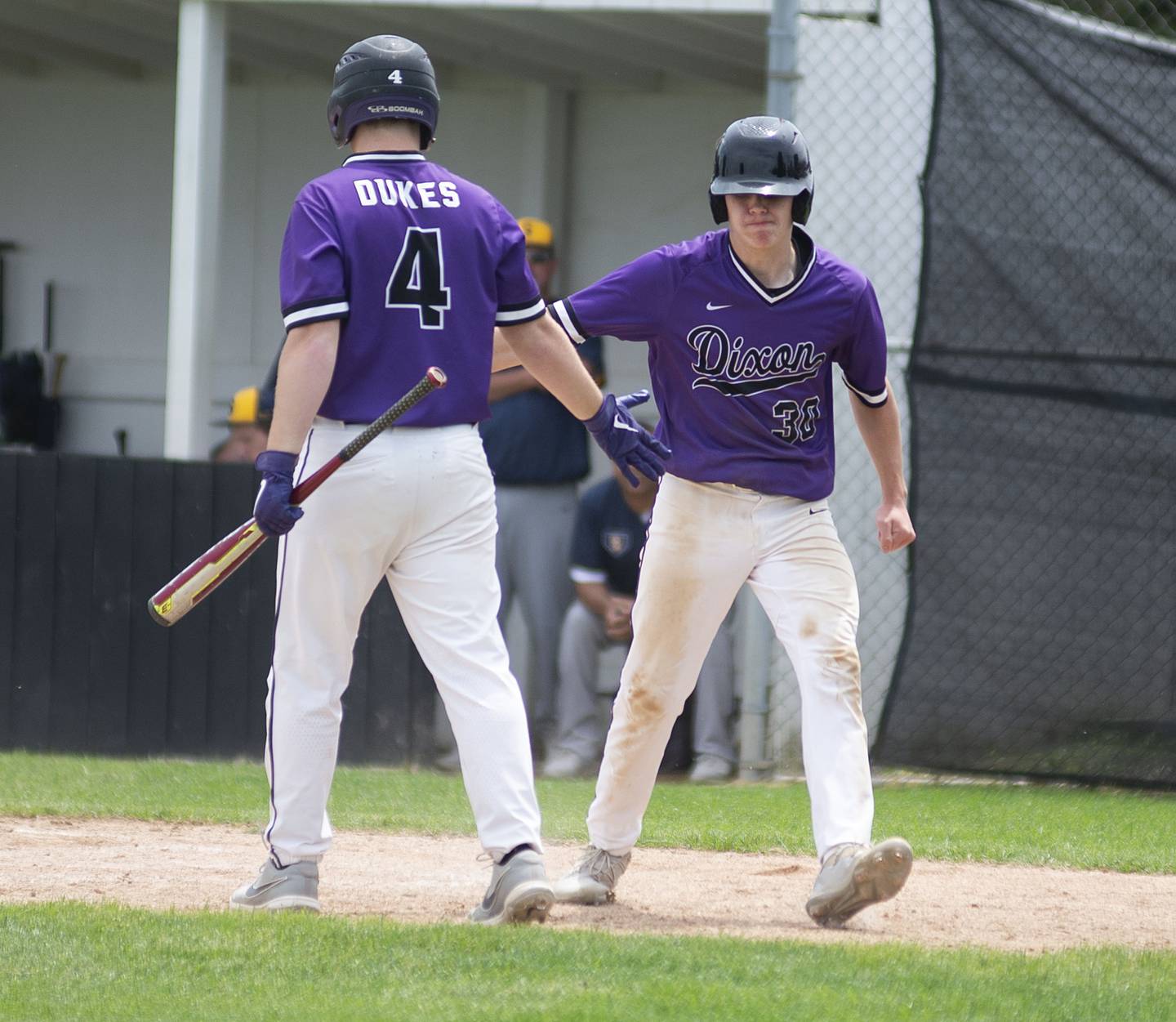Dixon’s Max Clark (right) celebrates after scoring on a wild pitch against Sterling on Saturday, May 28, 2022.