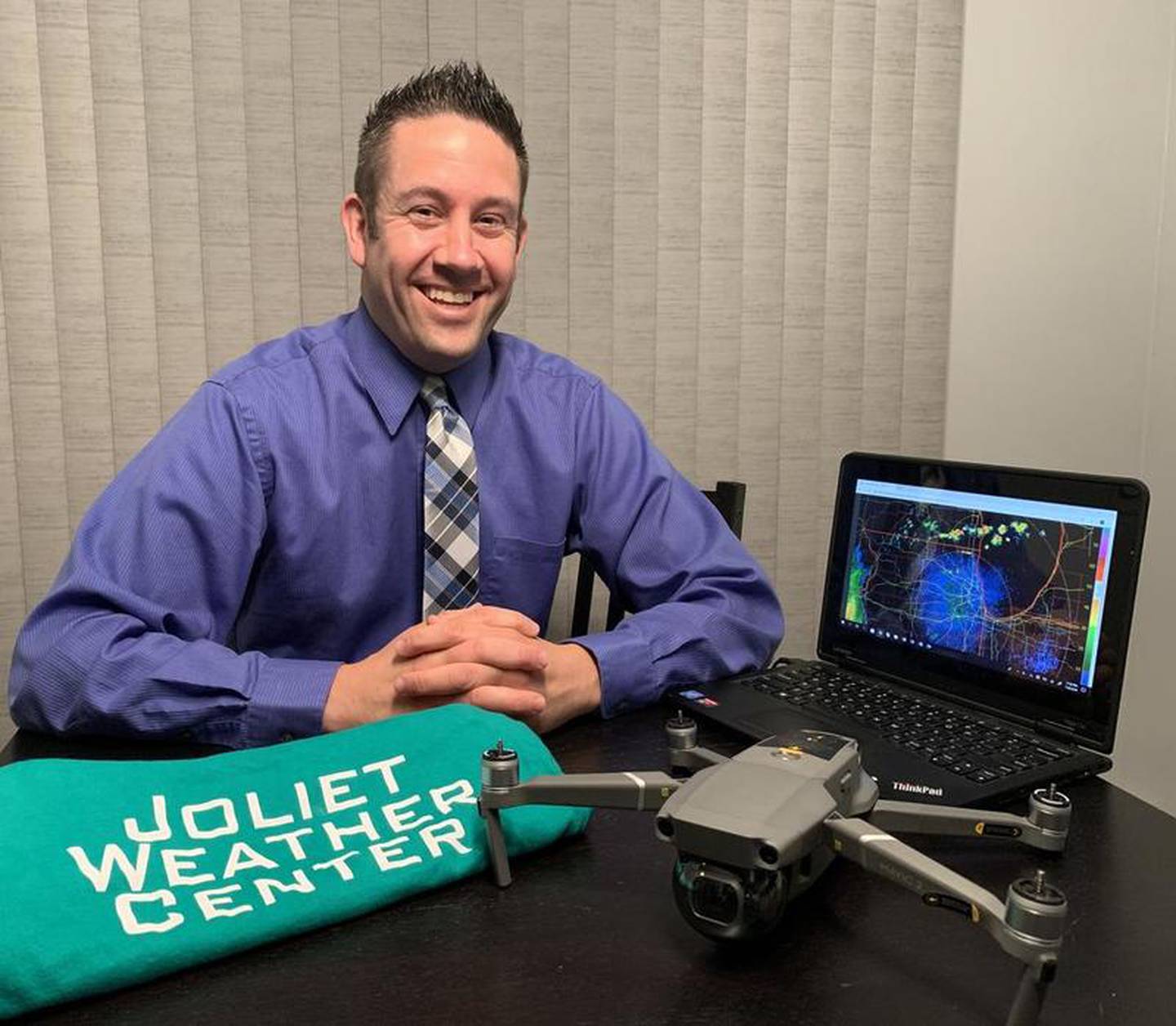 Jeremy Hylka, founder of the Joliet Weather Center, poses with the DJI Mavic Pro weather drone and computer software used for everyday forecasting.
