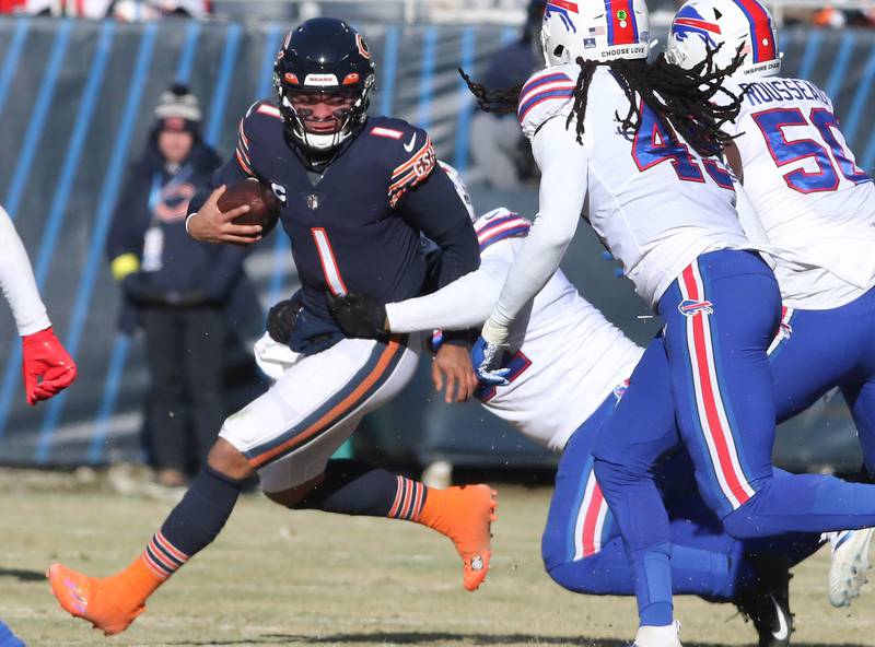 Chicago Bears quarterback Justin Fields scrambles away from the Buffalo Bills pass rush during their game Sunday, Dec. 24, 2022, at Soldier Field in Chicago.