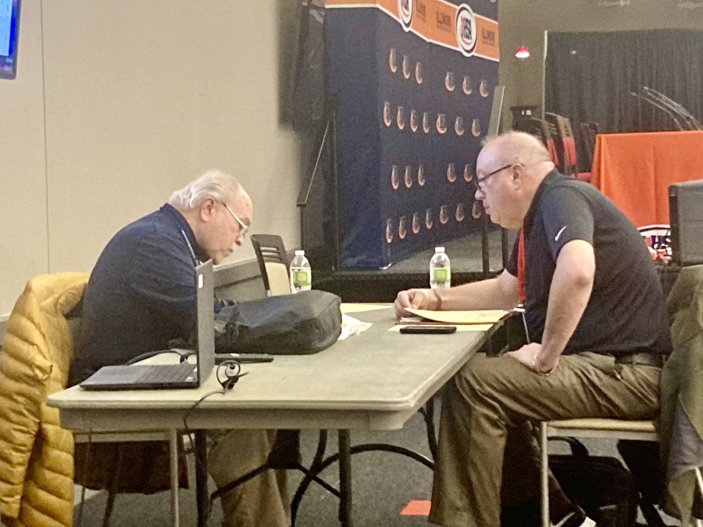 Ric Sipcovic (left) works  on his pregame niotes for St. Bede's third-place game Saturday evening in Normal. He is signing off after 40 years as radio broadcaster for WLPO.
