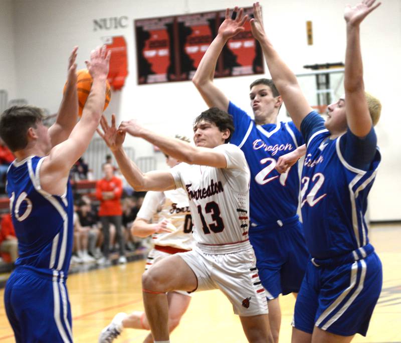 Forreston's Kendall Erdmann (13) passes the ball after driving the lane as Oregon's  Keaton Salsbury, Tucker O'Brien, and Kade Girton defend during a Saturday, Jan. 25, 2025 game at Forreston High School.