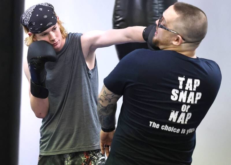 Joe Judkins, (right) head coach at Evolve MMA and Powerlifting, works on some punches with Chase Trautvetter, 16, from Sycamore during a class Thursday, Nov. 9, 2023, at the facility in DeKalb.