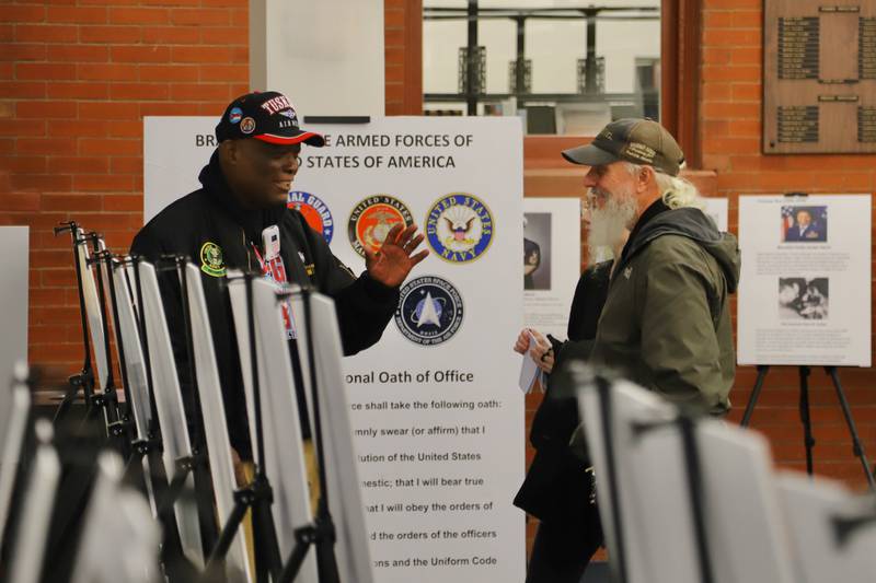 DeKalb resident Daniel "Doc" Habeel (left) speaks to a patron at the Sycamore Public Library in November 2024. Patrons came to view Habeel's "A Picture Exhibit of African American Patriots," a traveling photo exhibit he curated to share Black military history. The exhibit will begin traveling again in February 2025 in time for Black History Month.