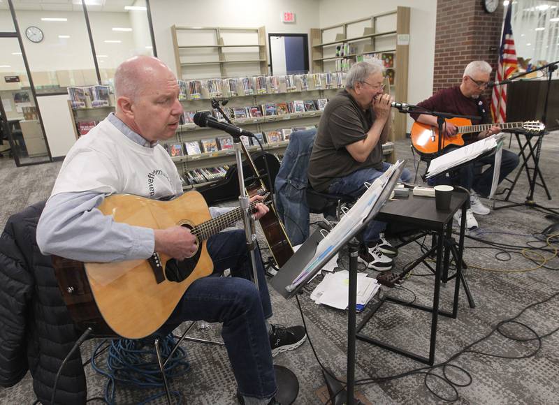 Dave Fletcher, of Waukegan, Gus Stagg, of Antioch and Stephen Jansen, of Lindenhurst, with the Gus Stagg Band, play classic rock and folk music Saturday, May 13, 2023, during the Antioch Public Library District Open House in Antioch.