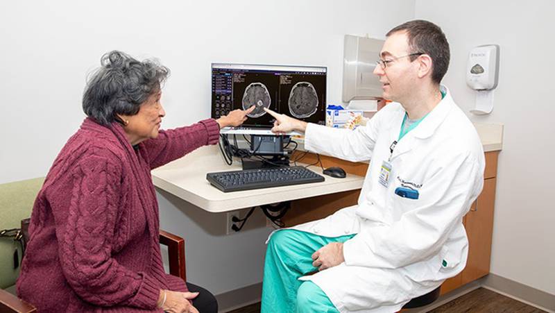 Edna Teodoro, 79, of New Lenox, is seen meeting with her University of Chicago Medicine neurosurgeon, Dr. Peleg Horowitz, at Silver Cross Hospital in New Lenox. Last summer, Horowitz performed a six-hour, complicated brain surgery on Teodora that's typically not available on the community level.