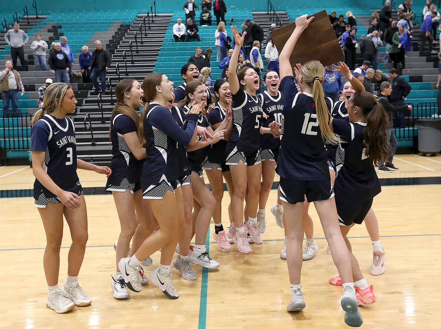 St. Viator's Emily Walberg and Gabriella Scaravalle raise the trophy to their teammates after the defeated Geneva in the IHSA Class 3A Woodstock North Supersectional girls basketball game on Monday, March 2, 2026, at Woodstock North High School.