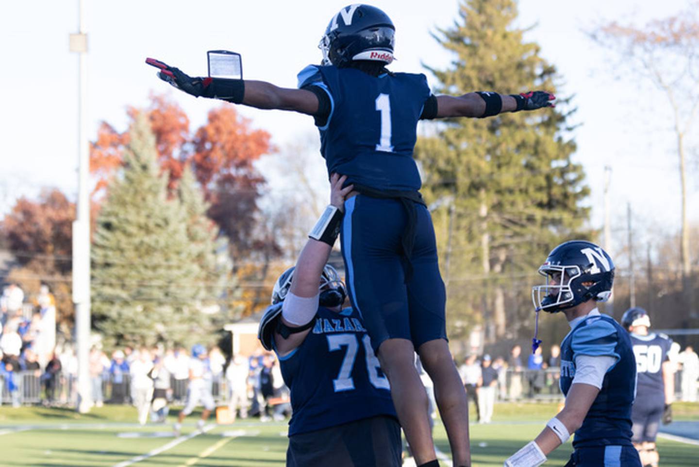 Nazareth lineman Christian Malachuk lifts up Trenton Walker after his game-winning catch during Saturday's Class 6A quarterfinal in La Grange Park.