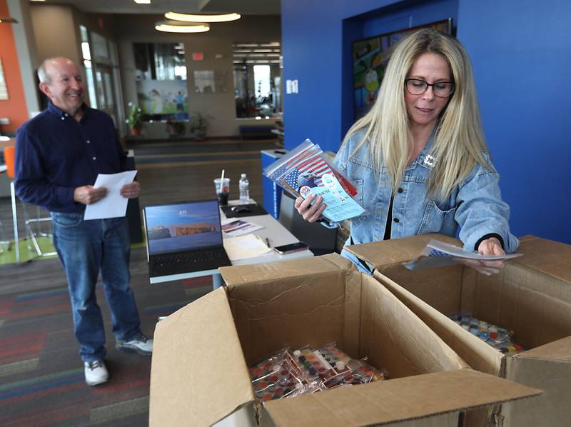 Barb Neises, a  volunteer with the McHenry Riverwalk Foundation, hands out tiles for the McHenry Riverwalk mural project on Thursday, April, 9, 2026, at the McHenry Recreation Center.