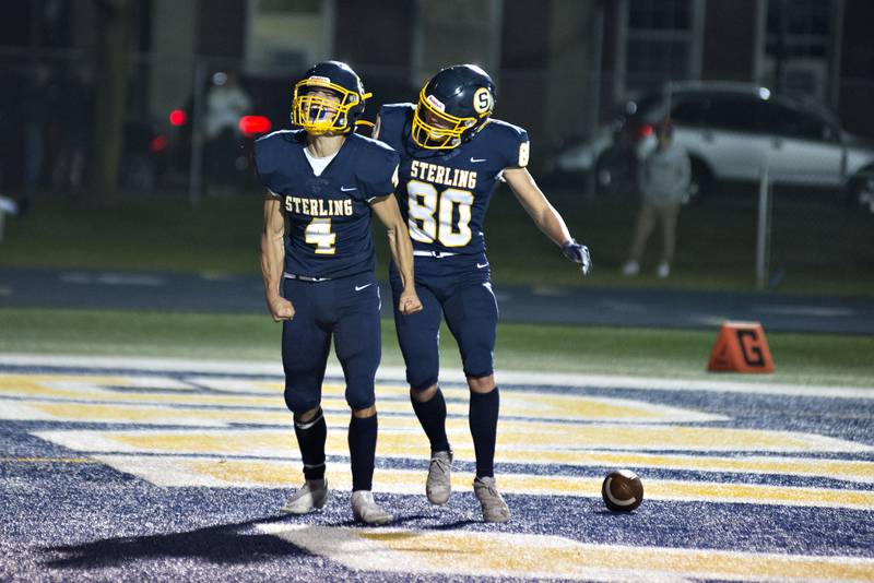 Sterling's Drew Kested (left) celebrates his touchdown with teammate Justin Null against Moline Friday, Oct. 15, 2021.