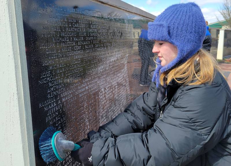 Audrey Olson of the RiverGlen Christian Church scrubs down the Middle East Conflicts Memorial Wall on Wednesday in Marseilles.