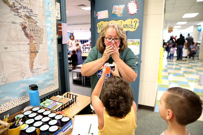 First grade teacher Kerry Rothman jokes with some of her students at Prairie Point Elementary School in Oswego during school supply drop-off ahead of the first day of school on Tuesday, Aug. 13, 2024.