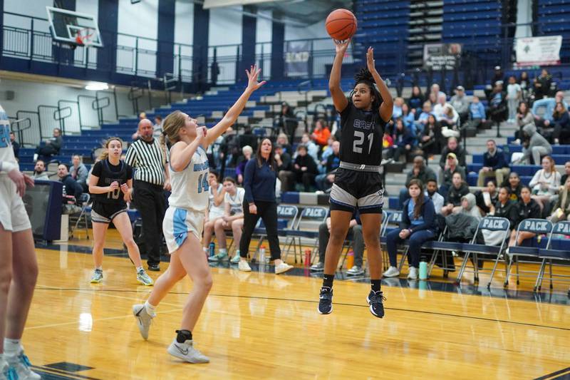 Oswego East's Desiree Merritt (21) shoots the ball on the wing against Downers Grove South's Allison Jarvis (14) during a 4A Oswego East Regional semifinal girls basketball game at Oswego East High School on Monday, Feb 12, 2024.