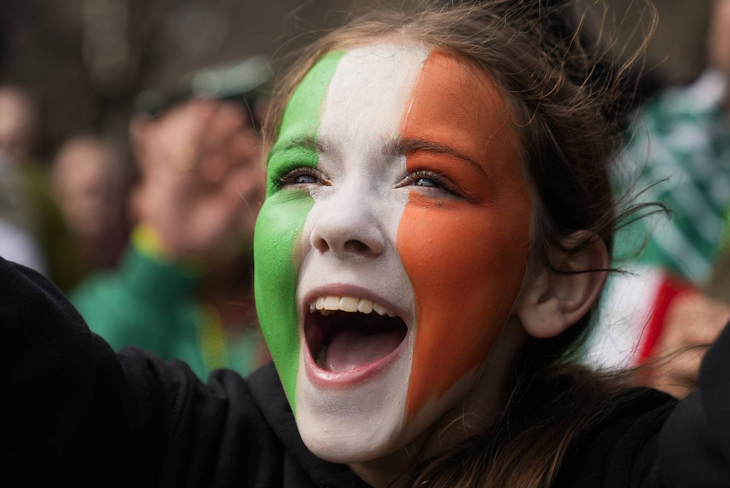 Eleven-year-old Ava Impell of Pittsburgh watches the St. Patrick's Day parade March 16, 2024, in Chicago.