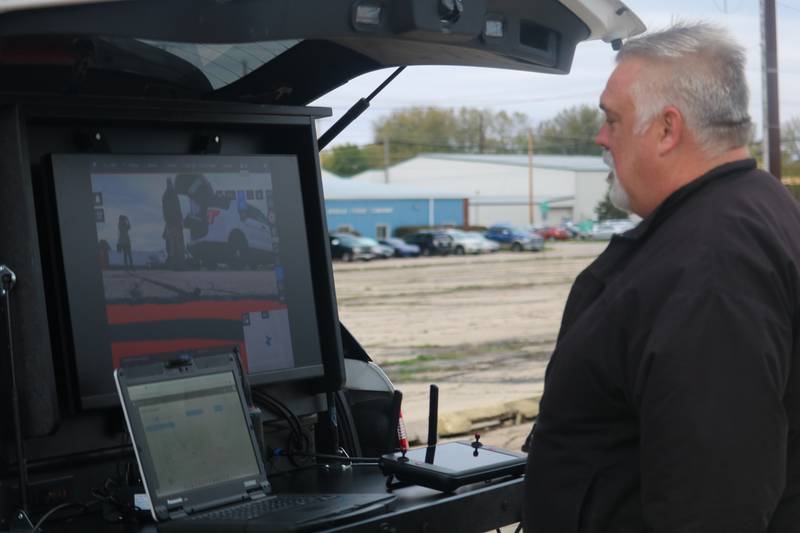 DeKalb Police Department Commander Craig Woodruff takes a look at a monitor  Oct. 22, 2025, surveying the land outside the former GE plant in DeKalb.
